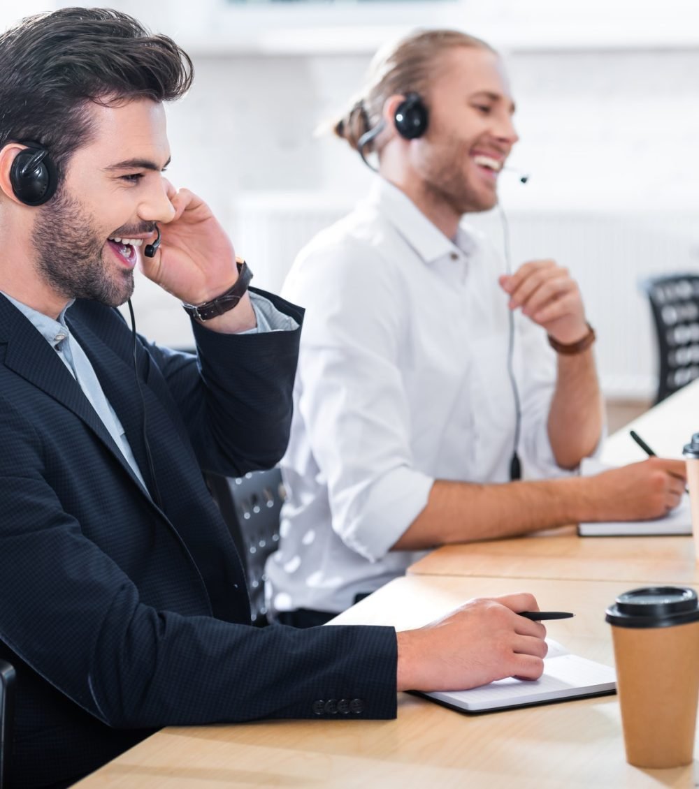 side-view-of-male-call-center-operators-in-headsets-at-workplace-in-office.jpg